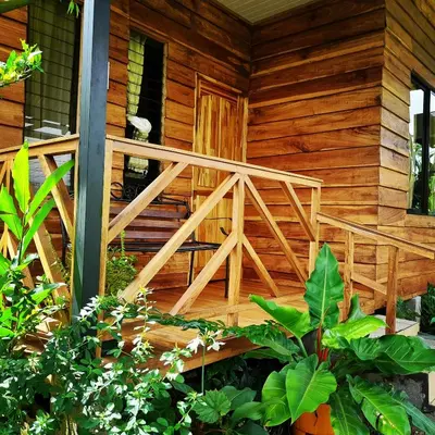 a wooden house with a wooden staircase on the side at Bungalow Batsù in Fortuna