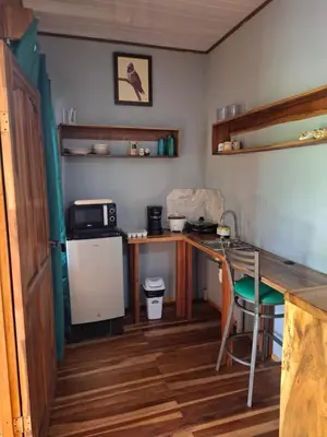 a small room with a desk and a microwave at Bungalow Batsù in Fortuna