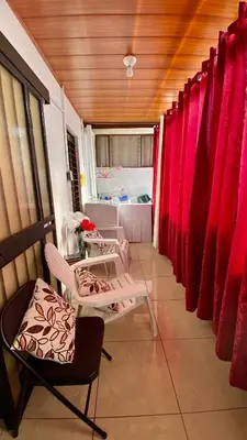 a room with two chairs and red curtains at Apartment 10 minutes by the SJO airport - in Alajuela City