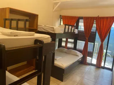 a room with four bunk beds and a window at Cabinas surf Arribadas in Playa Ostional