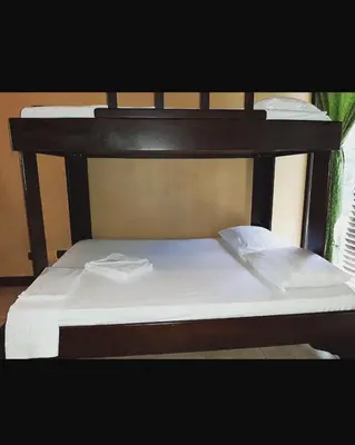 a black bunk bed with two white pillows on it at Cabinas surf Arribadas in Playa Ostional