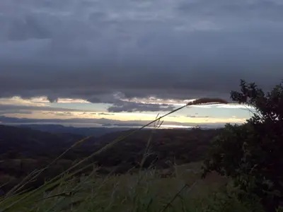 a view of the sunset from a hill with trees at Casa Alquimia in Monteverde Costa Rica