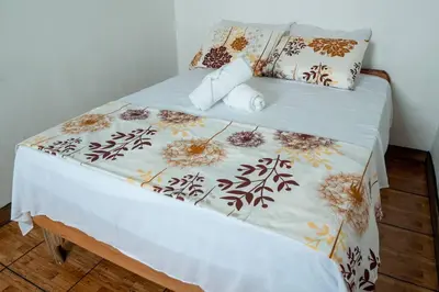 a bed with a white blanket and pillows on it at Tony's House in Fortuna