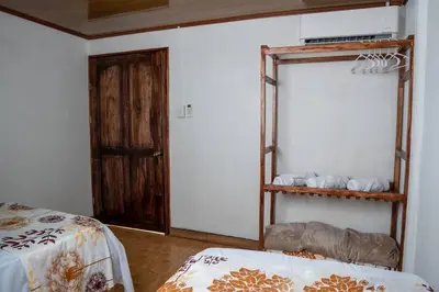 a room with a bed and a shelf with towels at Tony's House in Fortuna