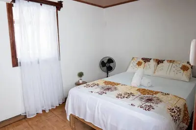 a bedroom with a bed and a window with a fan at Tony's House in Fortuna