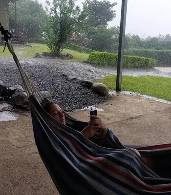 a woman laying in a hammock in the rain at Villa Golondrina Cabaña rodeada de Naturaleza in Monteverde Costa Rica