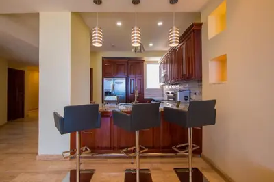 a kitchen with a bar with chairs in it at Break Water Point Penthouse 7th Floor in Jacó
