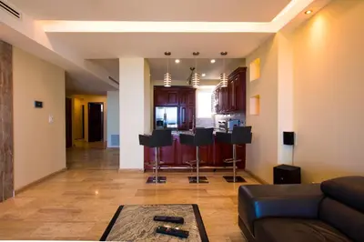 a living room with a couch and a kitchen at Break Water Point Penthouse 7th Floor in Jacó