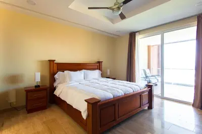 a bedroom with a large bed with a ceiling fan at Break Water Point Penthouse 7th Floor in Jacó