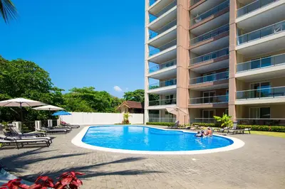 a swimming pool in front of a building at Break Water Point Penthouse 7th Floor in Jacó