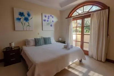 a bedroom with a large bed and a window at Casa Sol in Herradura