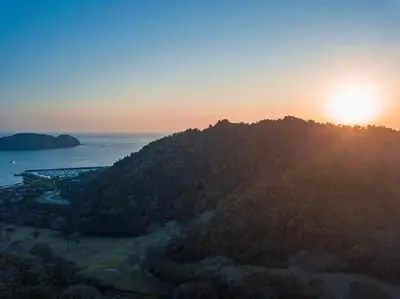 a sunset on a hill with the sun setting over the ocean at Casa Sol in Herradura