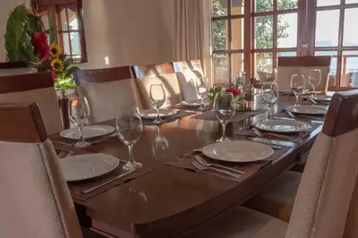 a long wooden table with plates and wine glasses at Casa Sol in Herradura