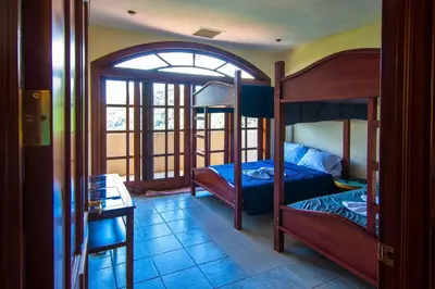 a bedroom with two bunk beds and a desk at Casa Sol in Herradura