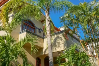 a building with palm trees in front of it at Casa Sol in Herradura