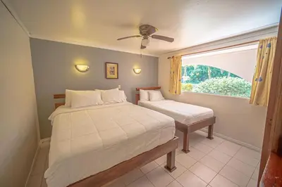a bedroom with two beds and a window at Lovely Condo near monkey habitat and beach in Quepos