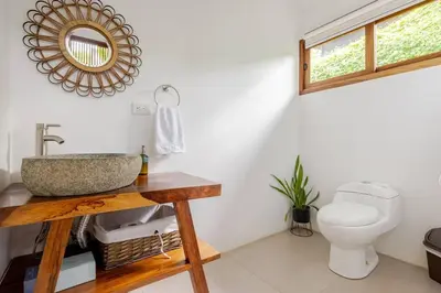 a bathroom with a sink and a toilet at Villa Fruta del Cielo in Uvita