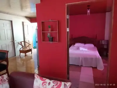 a bedroom with a red wall with a bed at Garden House in Fortuna