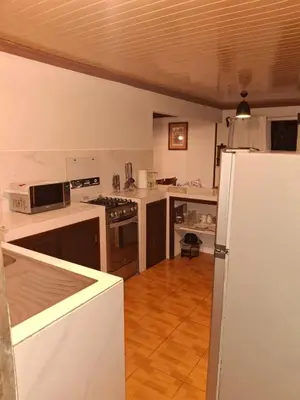 a kitchen with white counters and a white refrigerator at Garden House in Fortuna