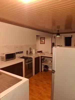 a kitchen with white counters and a white refrigerator at Garden House in Fortuna