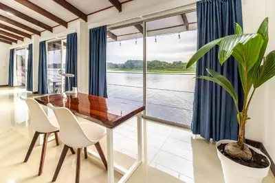 a dining room with a wooden table and chairs and a potted plant at The Babylon Suite Tortuguero in Tortuguero