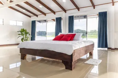 a bedroom with a large bed with red pillows at The Babylon Suite Tortuguero in Tortuguero