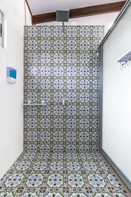a shower in a room with a tile wall at The Babylon Suite Tortuguero in Tortuguero