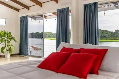 a bedroom with a large bed with red pillows at The Babylon Suite Tortuguero in Tortuguero