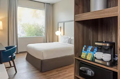 a hotel room with a bed and a coffee maker at Fairfield by Marriott San Jose Airport Alajuela in Alajuela City