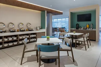a restaurant with tables and chairs and a counter at Fairfield by Marriott San Jose Airport Alajuela in Alajuela City