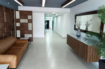 a living room with a brown couch and a table at Altamira Cozy apartment with amazing views in Santo Domingo