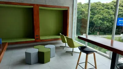 a waiting room with green seats and a table and chairs at Altamira Cozy apartment with amazing views in Santo Domingo