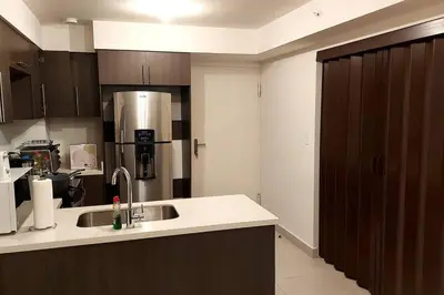 a kitchen with a sink and a refrigerator at Altamira Cozy apartment with amazing views in Santo Domingo