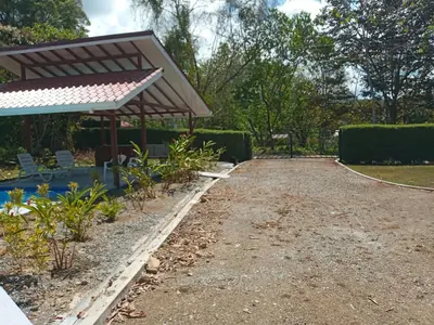 a garden with a pergola and a gravel driveway at Casa Hibiscus in Ojochal