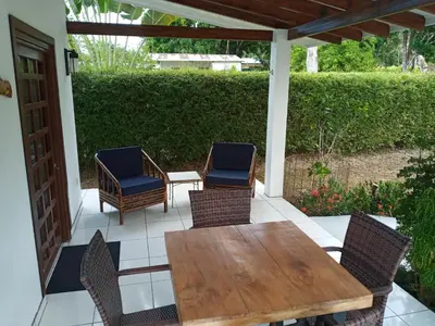 a patio with a wooden table and chairs at Casa Hibiscus in Ojochal