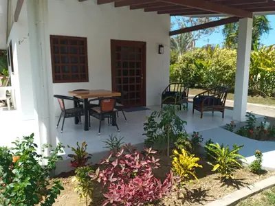 a patio with a table and chairs in a house at Casa Hibiscus in Ojochal
