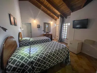 a bedroom with two beds and a flat screen tv at Hotel Ave del Paraíso in San José