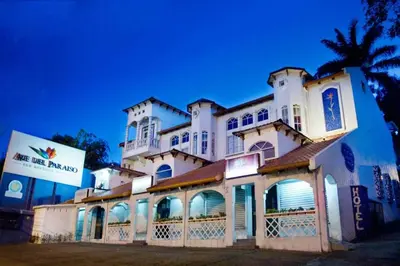 a large white building with a sign in front of it at Hotel Ave del Paraíso in San José