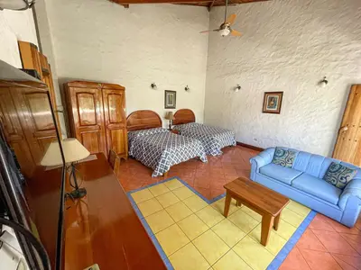 a living room with a blue couch and a table at Hotel Ave del Paraíso in San José