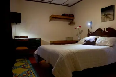 a bedroom with a large bed and a dresser and a bed sidx sidx sidx at Hotel Ave del Paraíso in San José