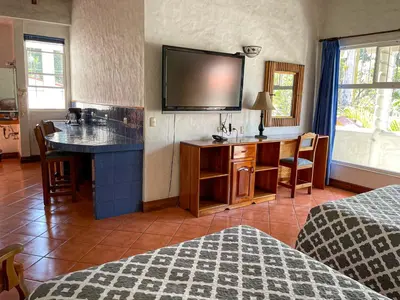 a hotel room with a bed and a tv on the wall at Hotel Ave del Paraíso in San José