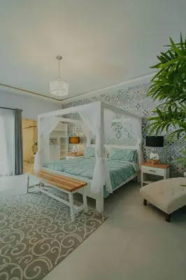 a bedroom with a canopy bed and a bench at Hotel Mono Azul in Quepos