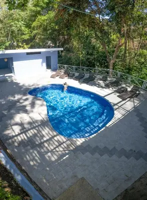 a swimming pool on a patio at Hotel Mono Azul in Quepos