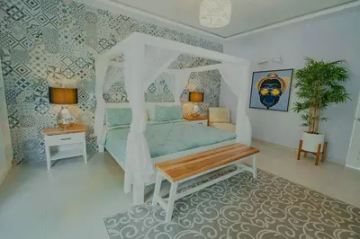 a bedroom with a canopy bed and a table at Hotel Mono Azul in Quepos