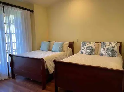 a bedroom with two beds and a window at 3 Bedroom Villa in Hacienda Pinilla in Tamarindo