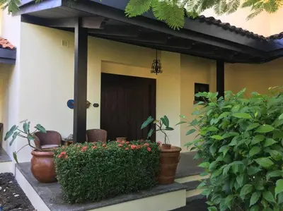 a house with plants and a door and a bush at 3 Bedroom Villa in Hacienda Pinilla in Tamarindo