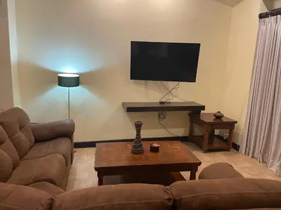 a living room with a couch and a flat screen tv at 3 Bedroom Villa in Hacienda Pinilla in Tamarindo
