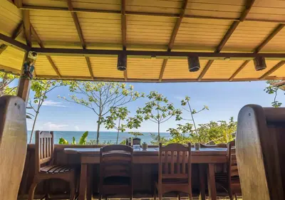 a table with chairs and a view of the ocean at La Cusinga Lodge in Uvita