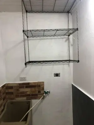 a bathroom with a urinal and a shelf on the wall at Pinky’s Place Airport, Full Equipment. in Alajuela City