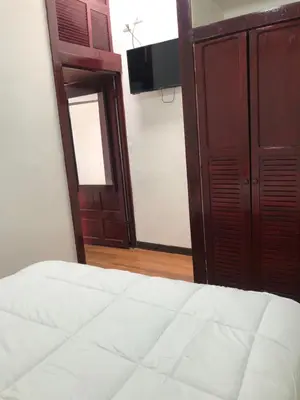 a bedroom with a bed and a cabinet and a television at Pinky’s Place Airport, Full Equipment. in Alajuela City